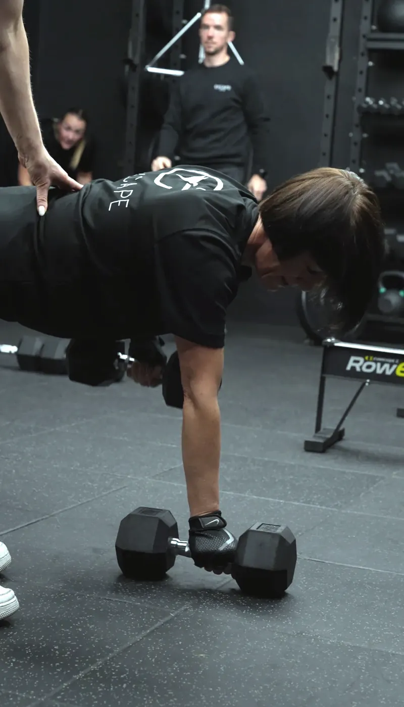 A coach correcting a member's row